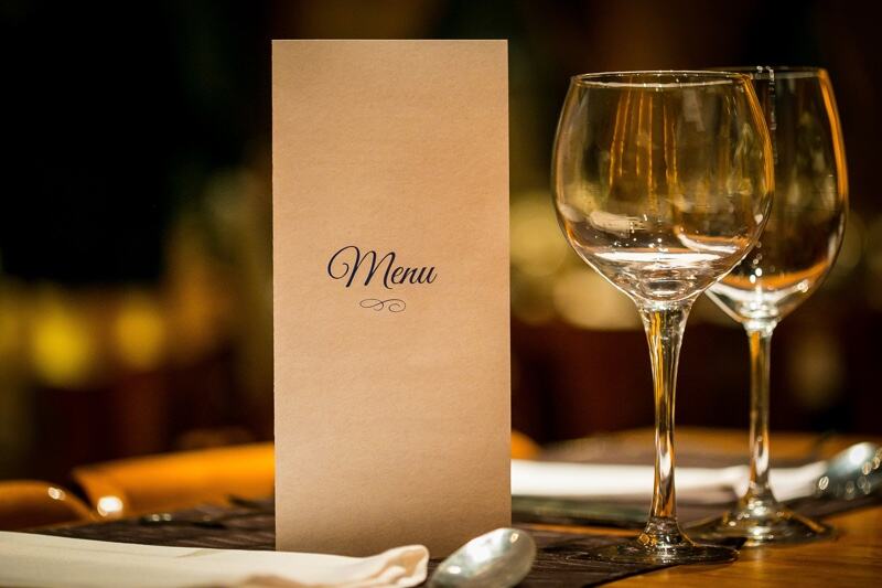 Fine dining table setup with a menu and wine glasses at Red Fox Supper Club in Helena, Montana.